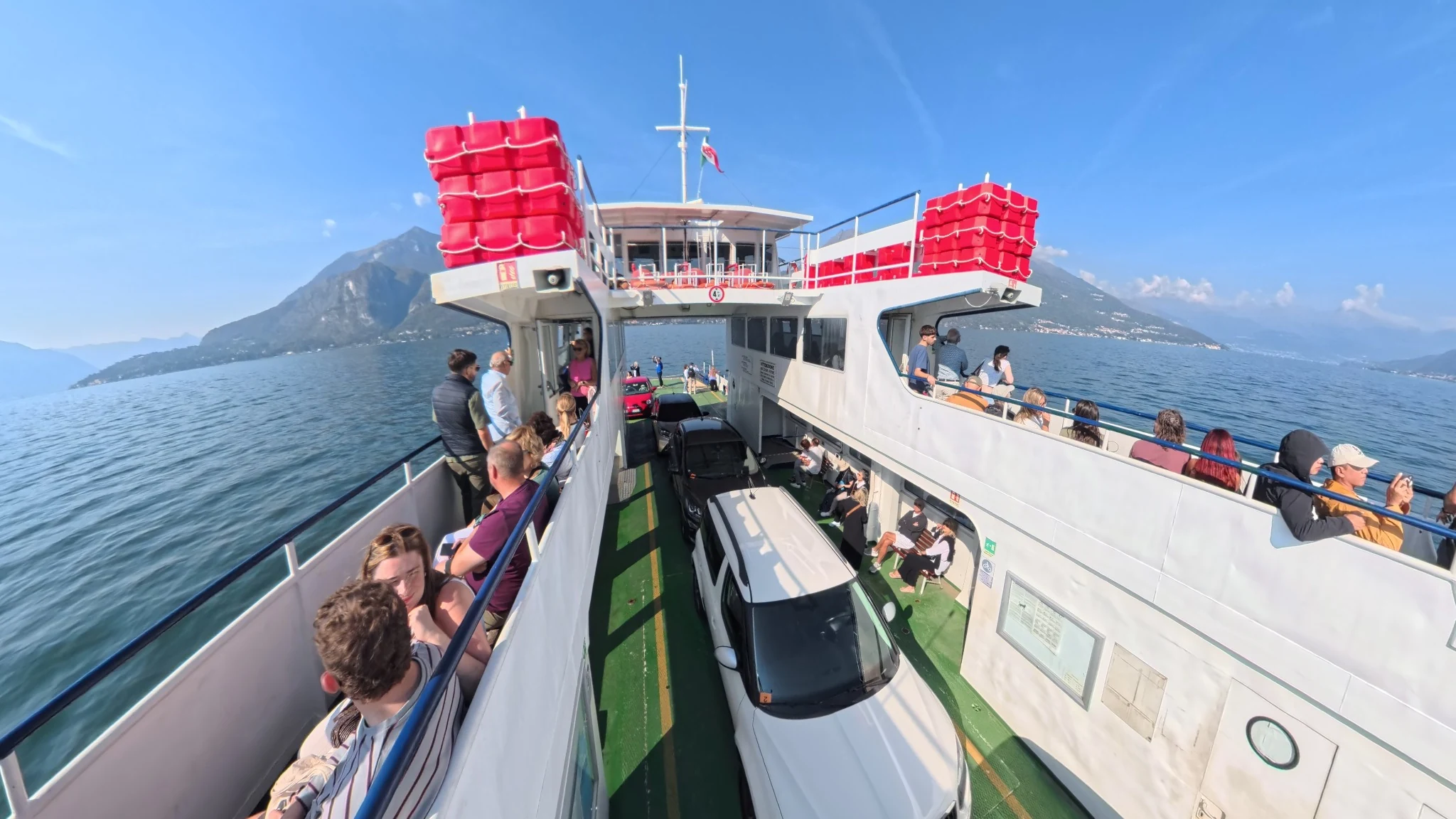 Pasażerowie i samochody na pokładzie promu Menaggio–Varenna